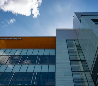 City hospital high-rise exterior under clear blue sky | Associated Nephrology Consultants | Maplewood MN