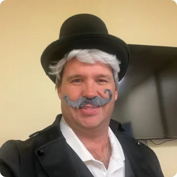 Person in costume with hat and painted mustache | Associated Nephrology Consultants | Maplewood MN