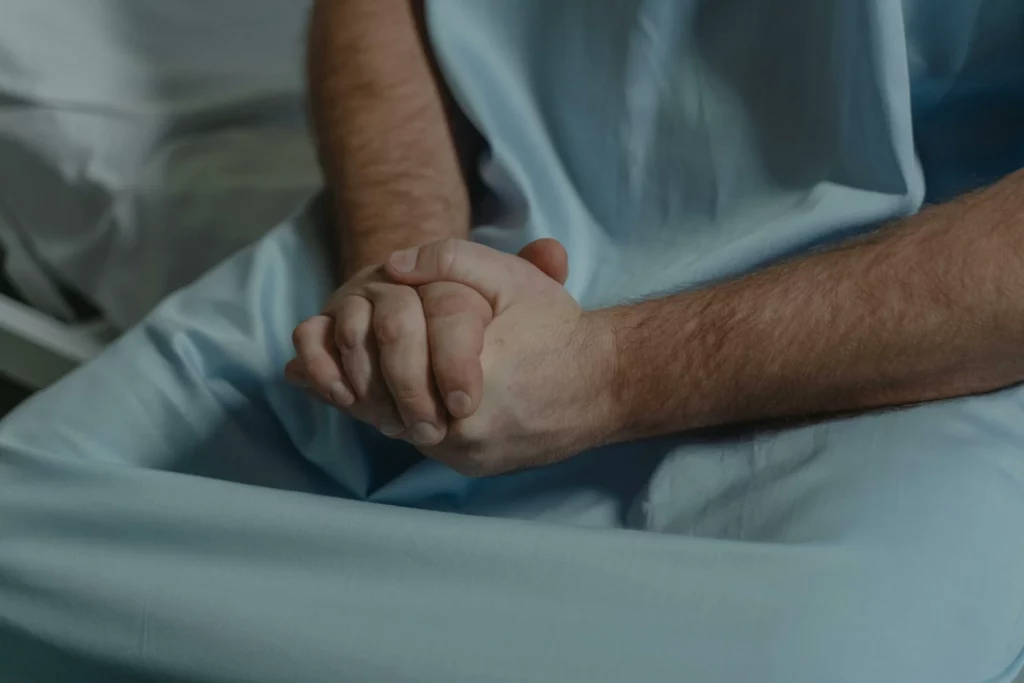 Patient sitting on hospital bed with hands clasped kidney care Maplewood MN