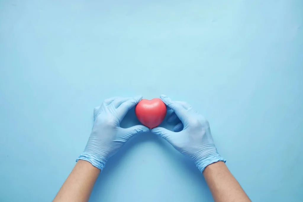 Gloved hands holding a red heart symbol to represent kidney and cardiovascular care Maplewood MN